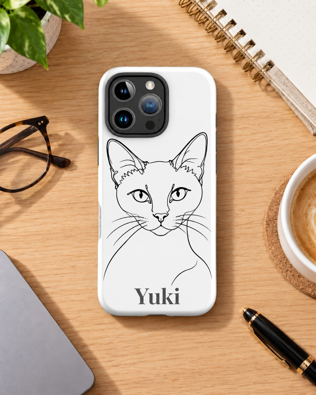 iPhone-Hülle mit Siamkatze im Minimal-Stil als Linienzeichnung und Namen Yuki, das Handy liegt auf dem Holztisch