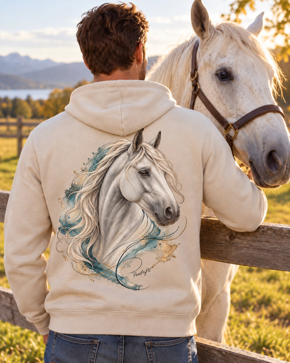 Mann im cremeweißen Hoodie mit Schimmel im Aquarell-Stil auf dem Rücken, vor ihm sein Pferd am Zaun