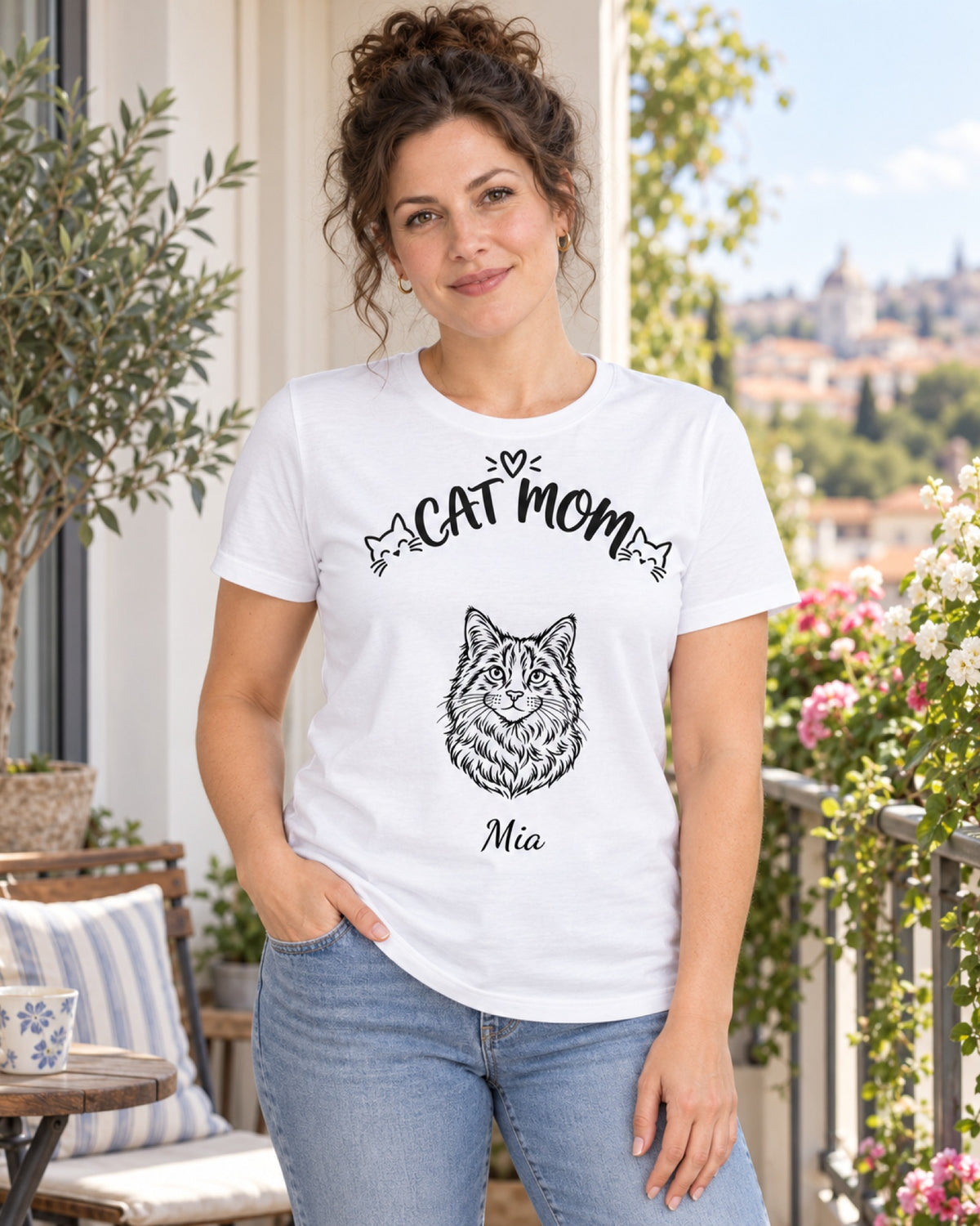 Frau im weißen T-Shirt „Cat Mom“ mit Katzenzeichnung und Namen Mia auf dem Balkon