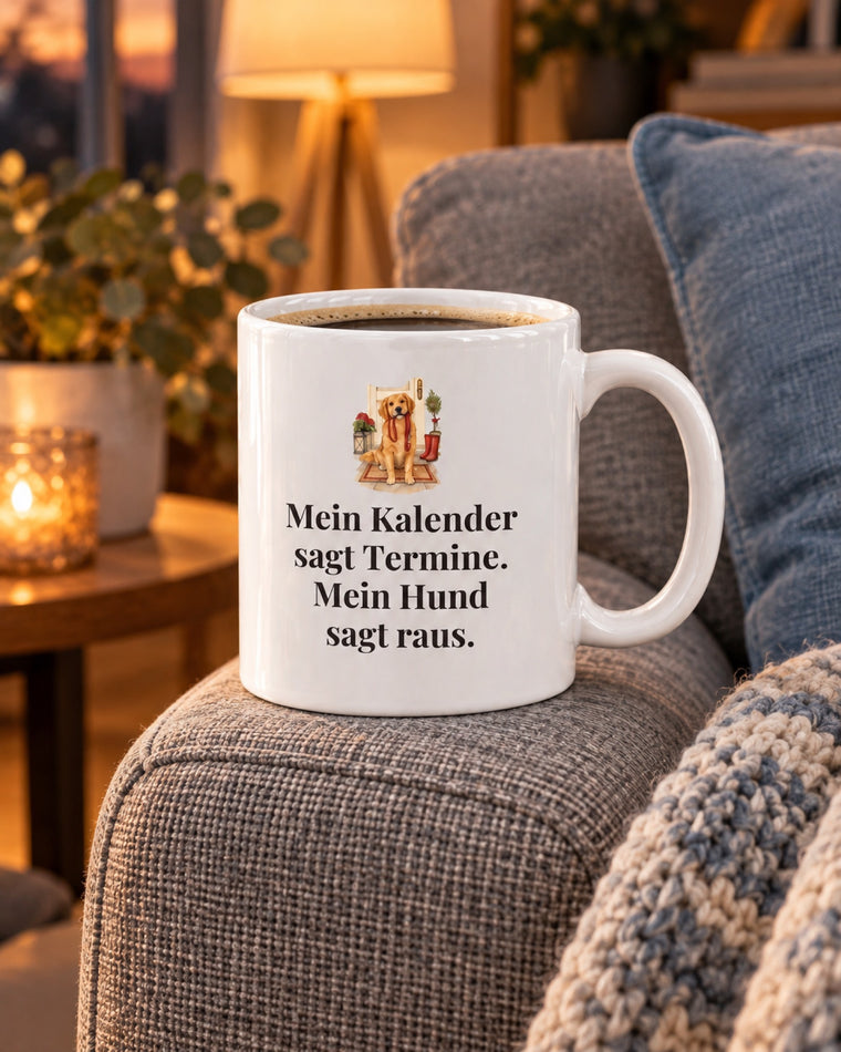 Weiße Keramiktasse Hundetasse mit Spruch: Mein Kalender sagt Termine. Mein Hund sagt raus. auf dem Sofa am Abend