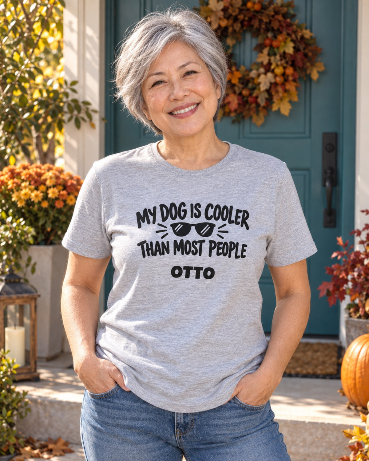 Frau im graumelierten My Dog Is Cooler Than Most People T-Shirt mit Beispielname Otto am petrolfarbenen Hauseingang