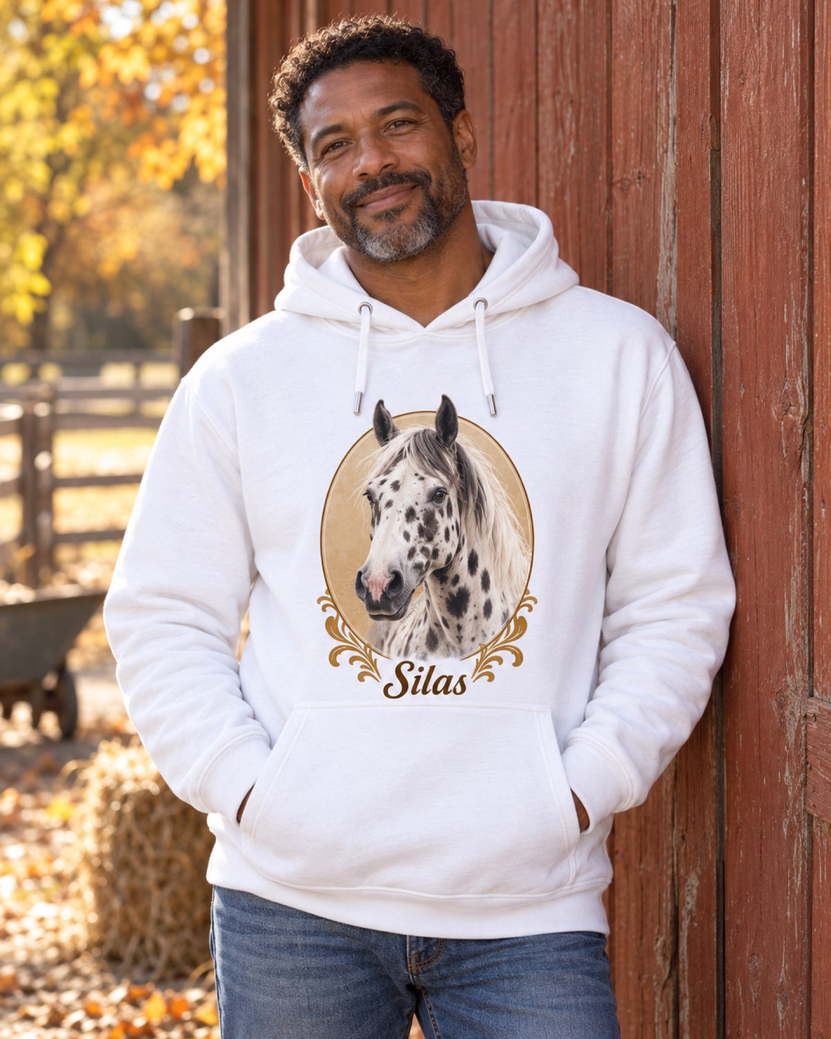 Mann im weißen Hoodie mit Tigerschecke Silas als Royalportrait an einer rostroten Scheunenwand