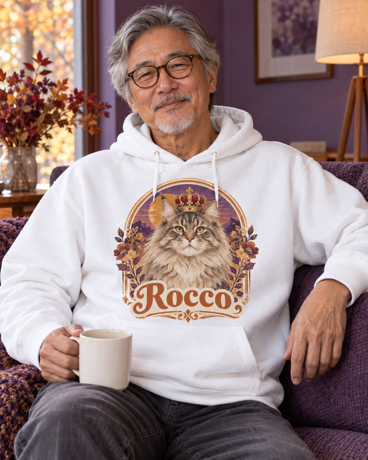 Mann im weißen Hoodie mit Maine Coon Rocco als Royalportrait im violetten Herbstwohnzimmer