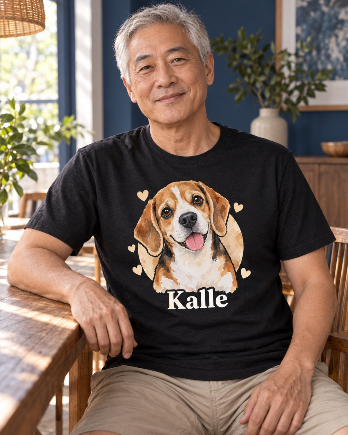 Mann im schwarzen T-Shirt mit Beagle Kalle als Cartoonportrait im tiefblauen Sommeresszimmer