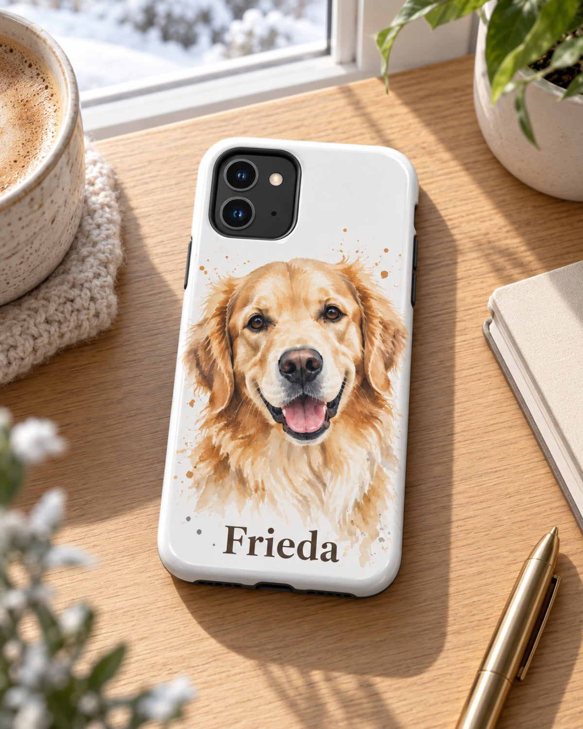 iPhone 11 Hülle mit Golden Retriever im Aquarell-Stil und Namen Frieda auf einem hellen Eichenschreibtisch am Winterfenster