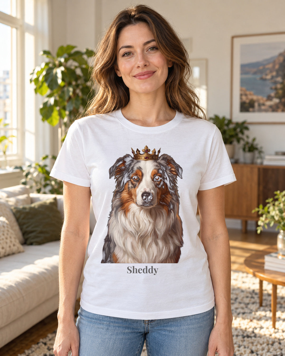 T-Shirt in Weiß mit Portrait von einem Australian Shepherd im Stil Royal und dem Namen Sheddy, getragen von einer Frau in einer hellen Wohnung